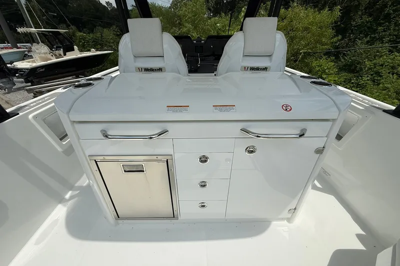 Slide: The Image of The 2026 Wellcraft 28 T-Top features a white onboard kitchen with drawers and a stainless steel compartment. - 20