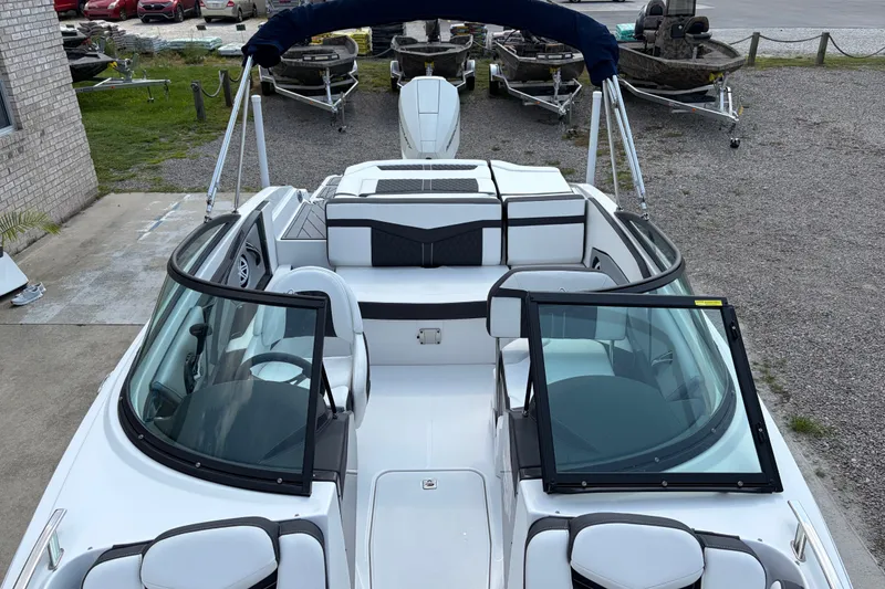 Slide: The Image of 2024 Monterey 215SS Super Sport boat with open windshield and seating, parked outdoors. - 14