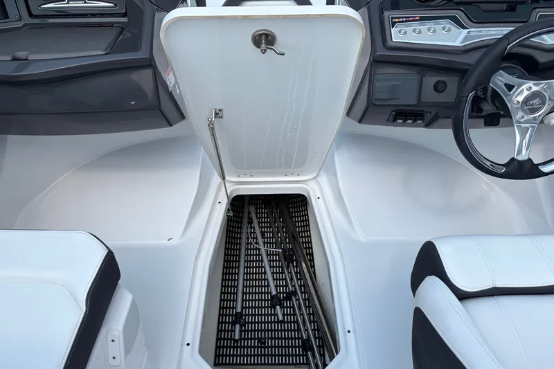 Slide: The Image of 2024 Monterey 215SS Super Sport boat interior with open storage compartment and steering wheel. - 19