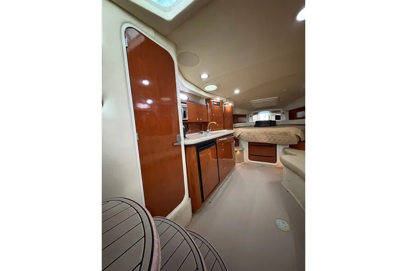 Slide: The Image of Interior of 2006 Sea Ray 340 Sundancer yacht, featuring kitchen and cozy sleeping area. - 25