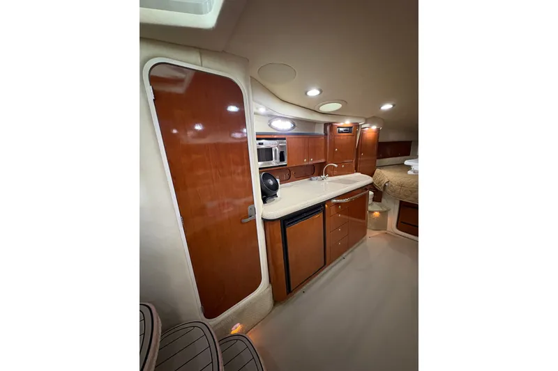 Slide: The Image of Luxurious interior of 2006 Sea Ray 340 Sundancer yacht with kitchenette and wood finishes. - 26