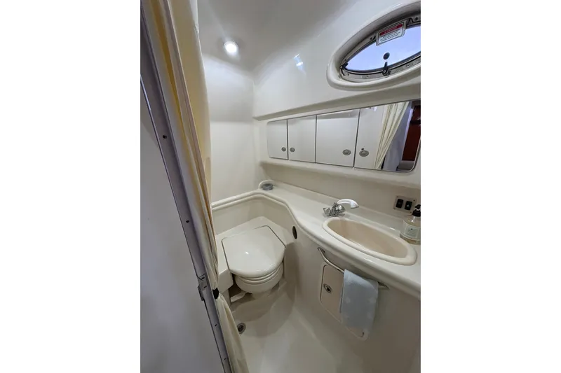 Slide: The Image of 2006 Sea Ray 340 Sundancer bathroom with sink, toilet, and mirror cabinet. - 29