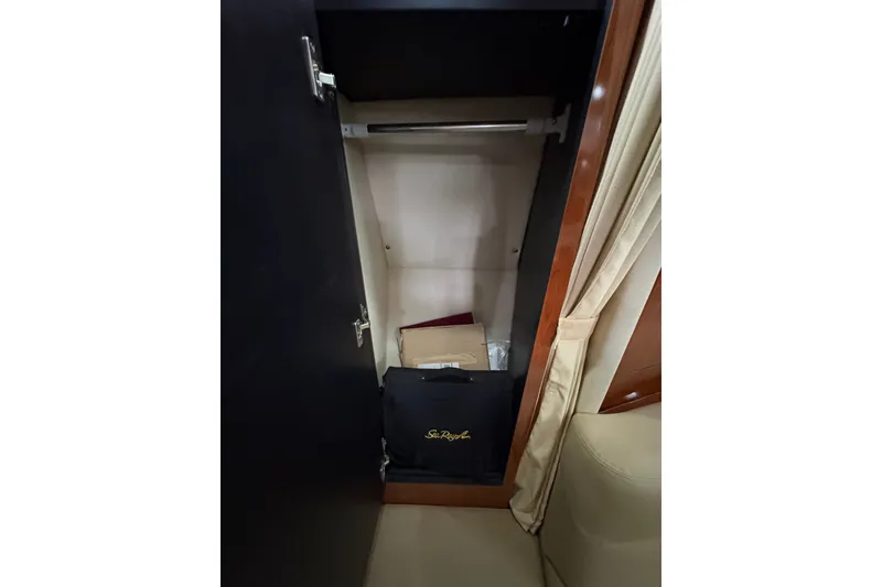 Slide: The Image of Open closet inside 2006 Sea Ray 340 Sundancer yacht, featuring storage space and Sea Ray bag. - 31