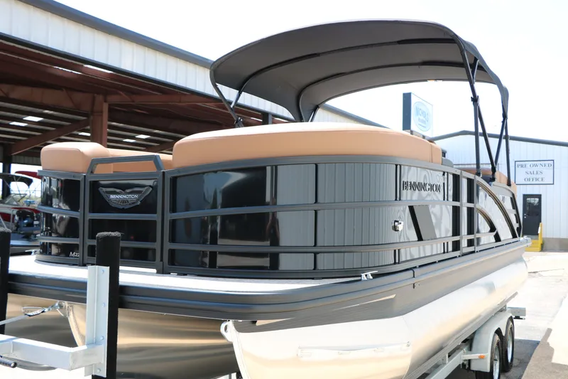 Slide: The Image of 2026 Bennington 22MFB pontoon boat with sleek design and canopy, displayed on a trailer. - 22
