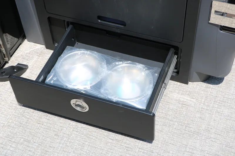 Slide: The Image of Open storage drawer on Bennington 22MFB 2026 boat, containing packaged items. - 30