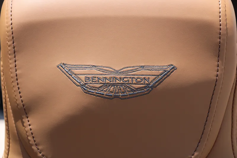 Slide: The Image of 2026 Bennington 22MFB seat with embroidered logo on tan leather upholstery. - 37