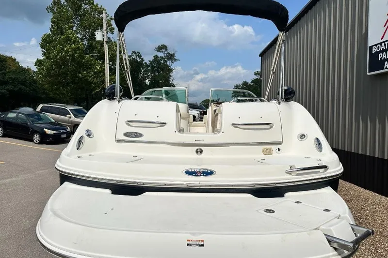 Slide: The Image of 2005 Chaparral Sunesta 274 boat with canopy, parked near a building. - 2