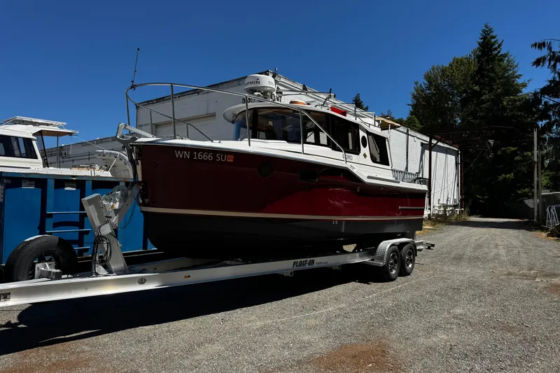 The Image of 2020 Ranger Tugs R-23 boat on trailer, parked outdoors under clear blue sky. - 0