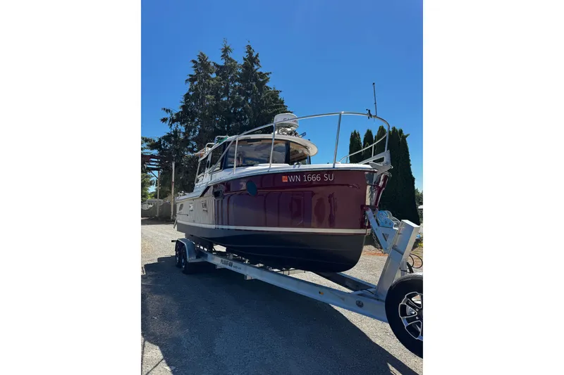 Slide: The Image of 2020 Ranger Tugs R-23 boat on trailer, parked outdoors under clear blue sky. - 1