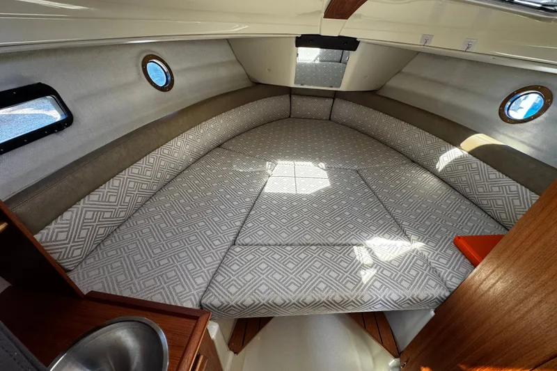 Slide: The Image of 2020 Ranger Tugs R-23 cabin interior with patterned cushions and porthole windows. - 10