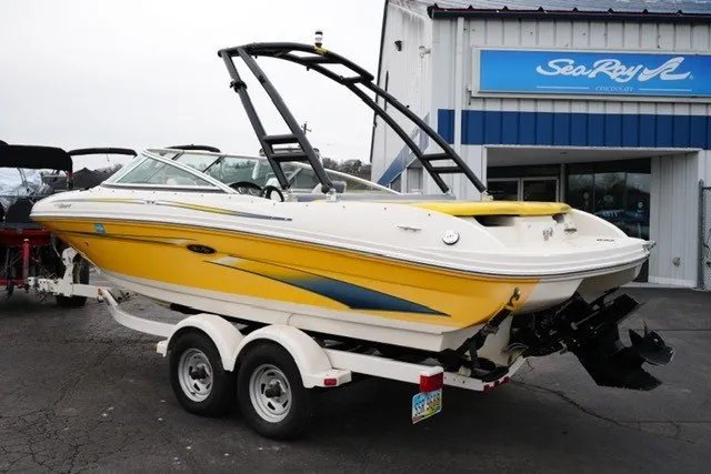 Slide: The Image of 2006 Sea Ray 205 Sport boat in yellow, parked on a trailer outside a dealership. - 9