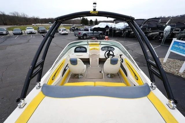 Slide: The Image of 2006 Sea Ray 205 Sport boat interior with yellow accents, parked in a lot. - 8