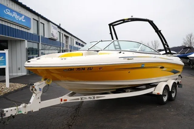 Slide: The Image of 2006 Sea Ray 205 Sport boat in yellow on trailer outside dealership. - 14
