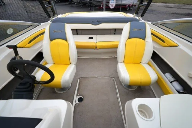 Slide: The Image of 2006 Sea Ray 205 Sport boat interior with yellow and white seating, steering wheel, and spacious layout. - 6