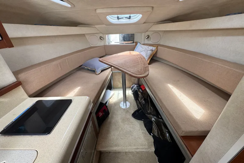 Slide: The Image of Interior of 2006 Sea Ray Sundancer 260, featuring cozy seating and a central table. - 17