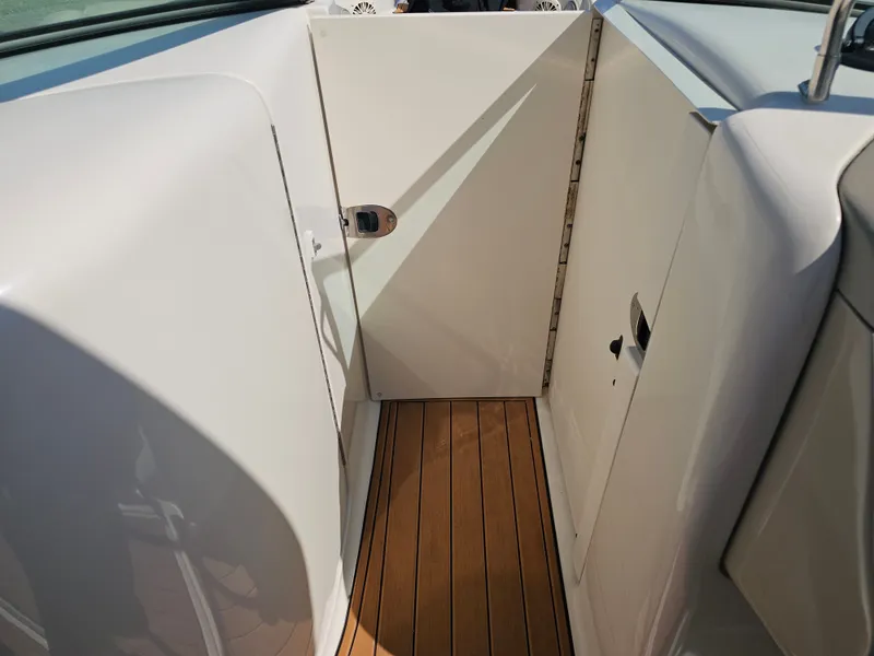 Slide: The Image of The 2006 Sea Ray 270 Sundeck features a well-maintained interior with wood flooring and white walls. - 27