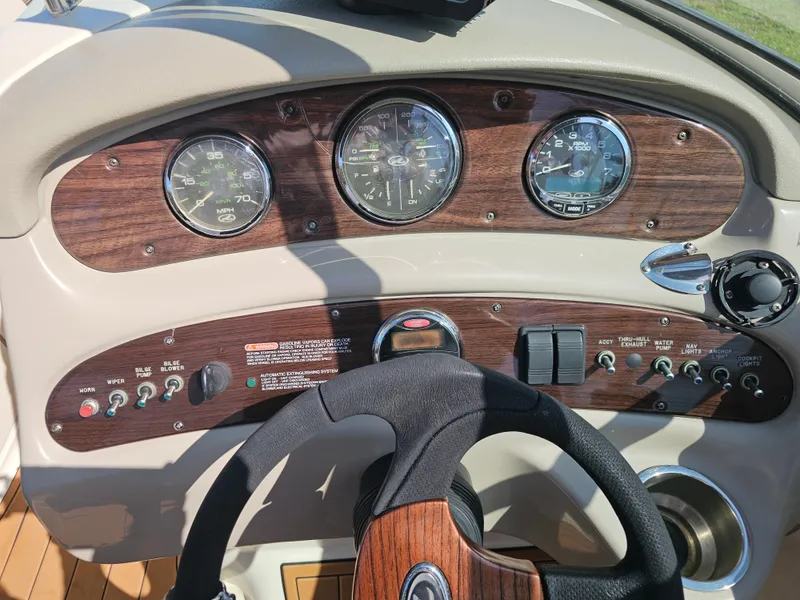 Slide: The Image of The image shows the dashboard of a 2006 Sea Ray 270 Sundeck boat with wood accents and gauges. - 37