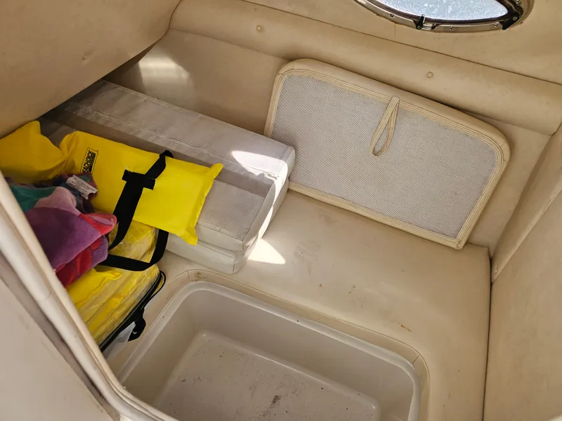 Slide: The Image of Interior of a 2006 Sea Ray 270 Sundeck with storage space and life jackets. - 29