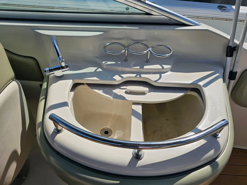 Slide: The Image of A sink with a faucet and cup holders on a boat, surrounded by beige and green interior. - 25