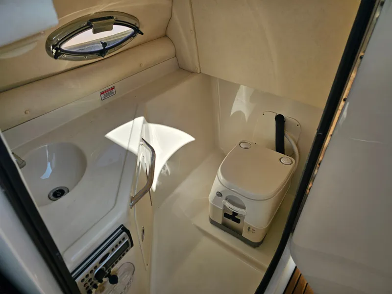Slide: The Image of The image shows a compact boat toilet with a sink and porthole. - 26