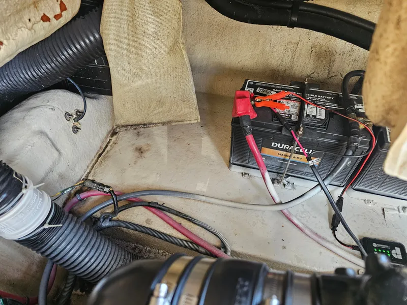 Slide: The Image of A battery compartment with a Duralast battery and cables in a Sea Ray 270 Sundeck boat. - 23