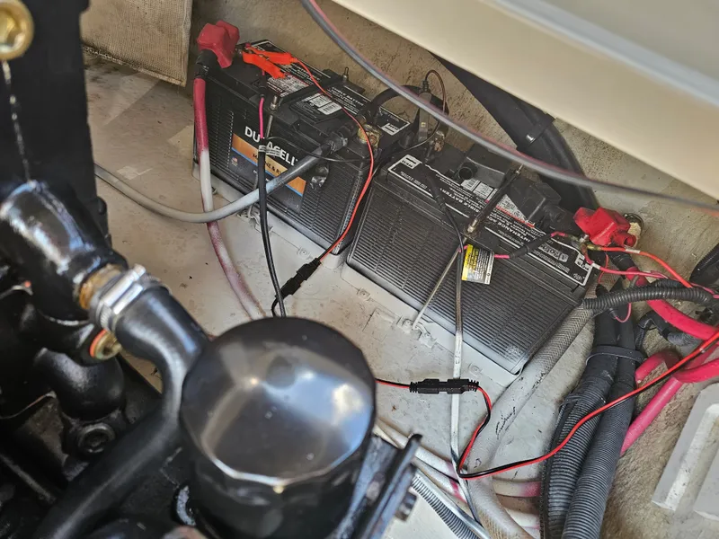Slide: The Image of Batteries and wiring in a boat's engine compartment, with visible hoses and cables. - 17