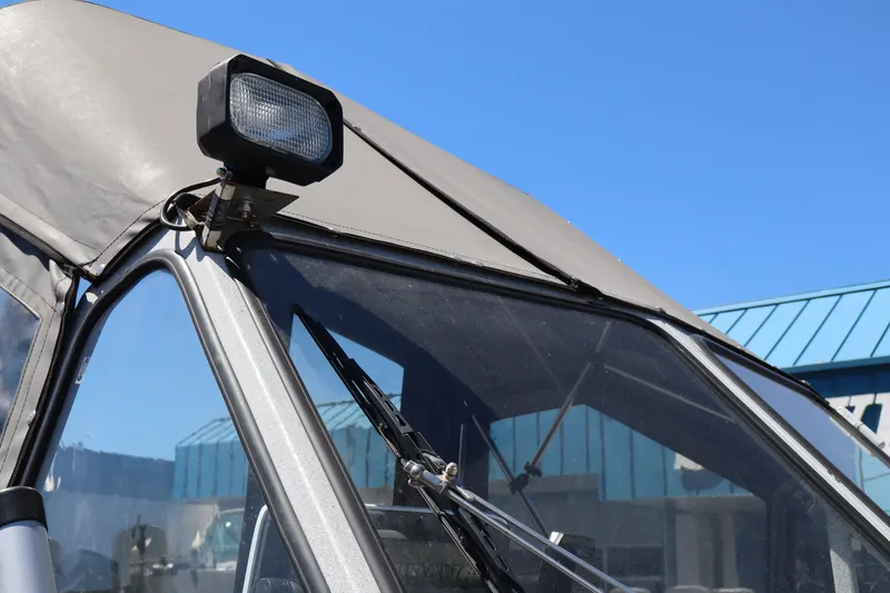 Slide: The Image of Close-up of a 2005 Jetcraft 1625 SK boat windshield and spotlight under clear blue sky. - 20