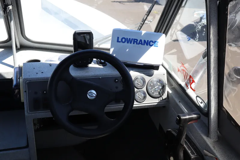 Slide: The Image of Interior of a 2005 Jetcraft 1625 SK boat with steering wheel and navigation equipment. - 12