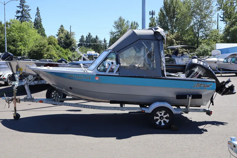 Slide: The Image of 2005 Jetcraft 1625 SK boat on trailer, parked outdoors with trees in background. - 3