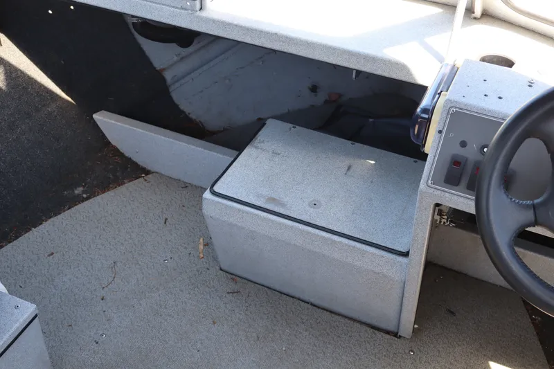 Slide: The Image of Interior of a 2005 Jetcraft 1625 SK boat showing steering wheel and storage compartment. - 14