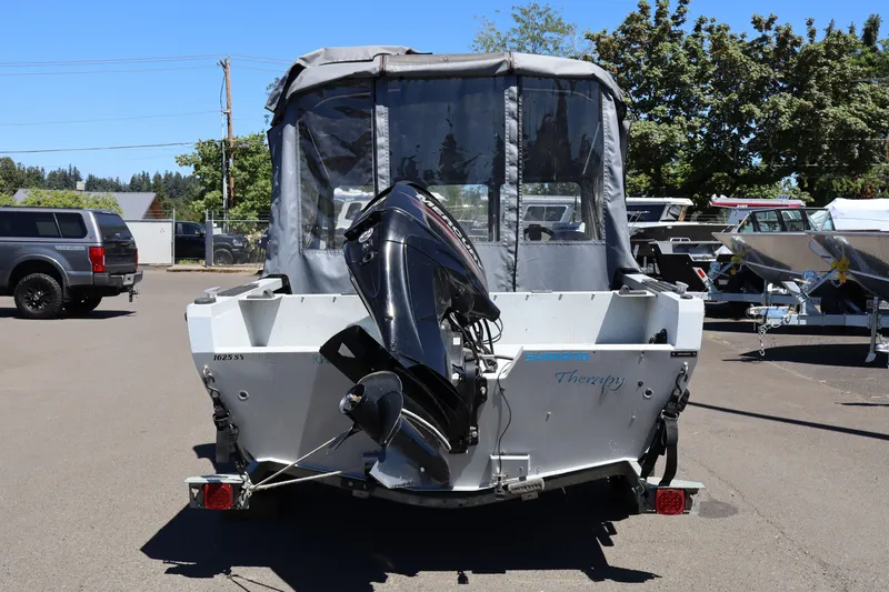 Slide: The Image of 2005 Jetcraft 1625 SK boat with outboard motor, parked outdoors on a sunny day. - 4