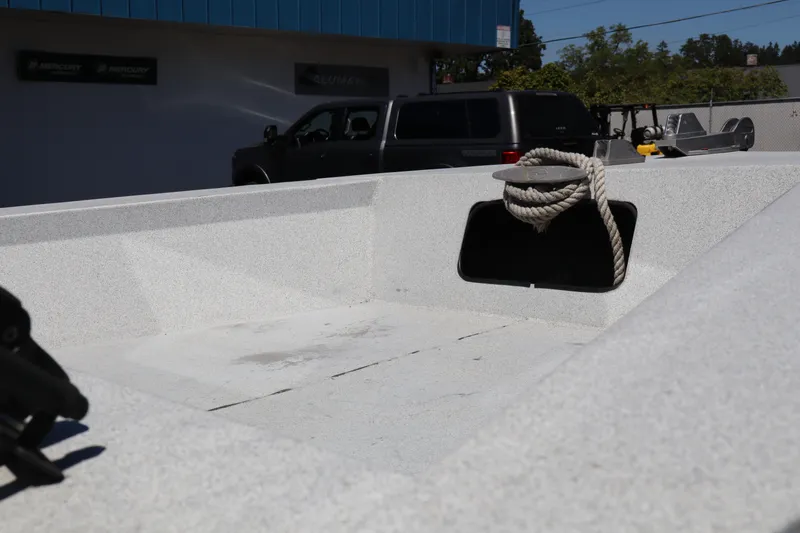 Slide: The Image of 2005 Jetcraft 1625 SK boat interior with rope, parked near a building. - 21
