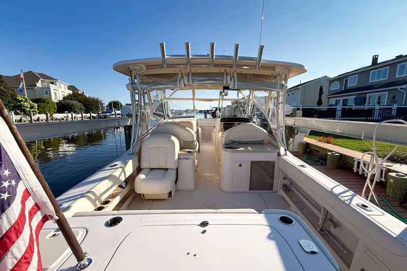 Slide: The Image of 2012 Grady-White Freedom 307 boat docked, featuring spacious seating and clear canopy. - 15