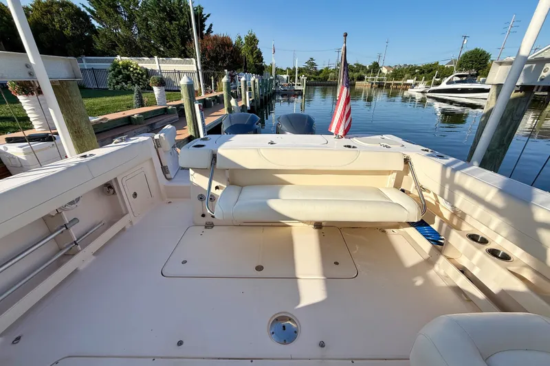 Slide: The Image of 2012 Grady-White Freedom 307 boat docked, featuring spacious seating and American flag. - 19