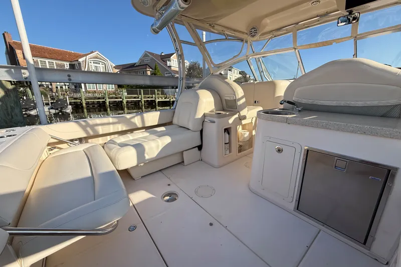 Slide: The Image of 2012 Grady-White Freedom 307 boat interior with seating and storage, docked by waterfront homes. - 20