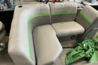 Slide: The Image of 2022 Angler Qwest 820XRE Cruise LT boat seating with green accents and cup holders. - 12