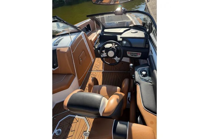 Slide: The Image of 2019 Nautique Super Air Nautique G25 boat interior with brown and black seating. - 5