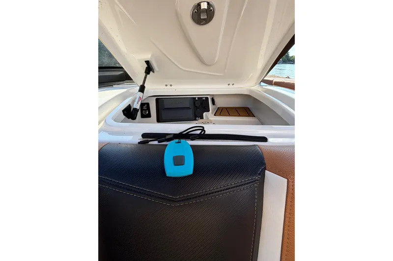 Slide: The Image of 2019 Nautique Super Air Nautique G25 interior storage compartment with blue key fob. - 13