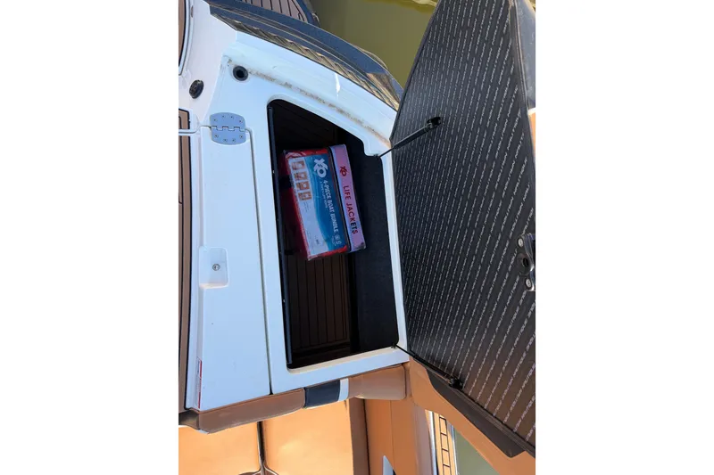 Slide: The Image of Open storage compartment of 2019 Nautique Super Air Nautique G25 with life jacket bundle. - 8