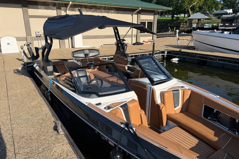 Slide: The Image of 2019 Nautique Super Air Nautique G25 boat docked, featuring sleek design and luxurious seating. - 7