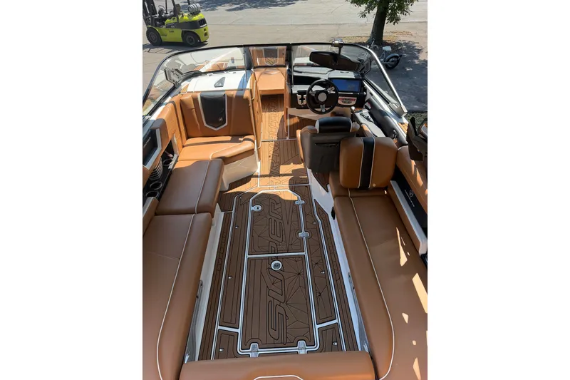 Slide: The Image of 2019 Nautique Super Air Nautique G25 interior with tan seating and sleek dashboard design. - 17