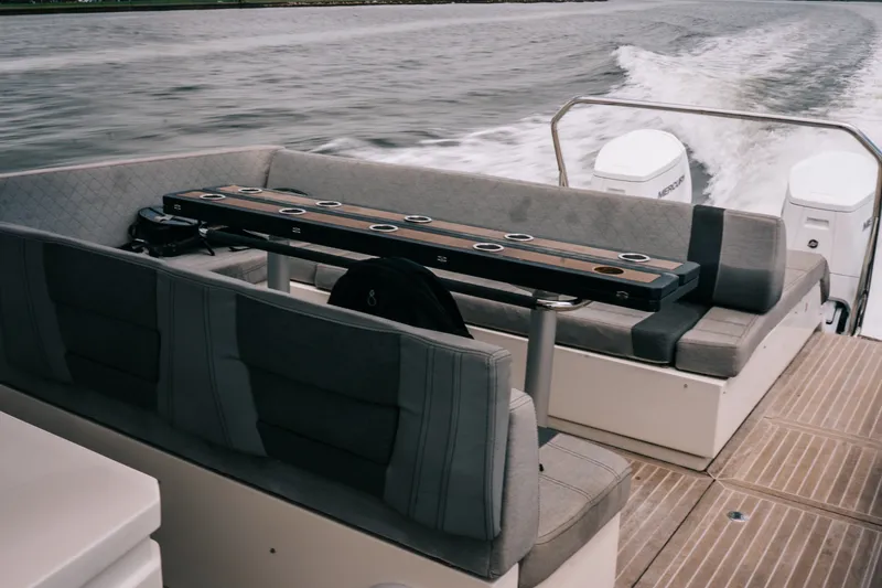 Slide: The Image of The image shows the stern of a 2022 Windy SR44 boat with gray seating and a table. - 10