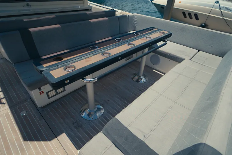 Slide: The Image of The image shows the seating area of a 2022 Windy SR44 boat with a table and cushioned benches. - 11