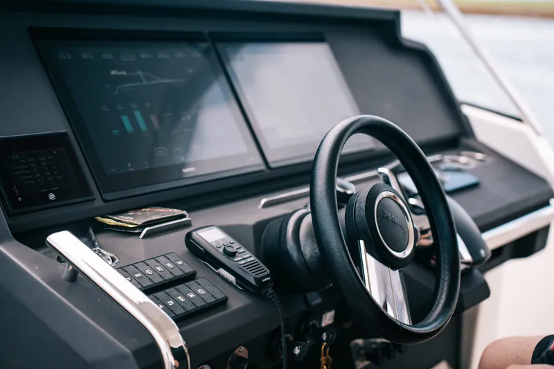 Slide: The Image of Steering wheel and dashboard of 2022 Windy SR44 boat, featuring modern controls and displays. - 14