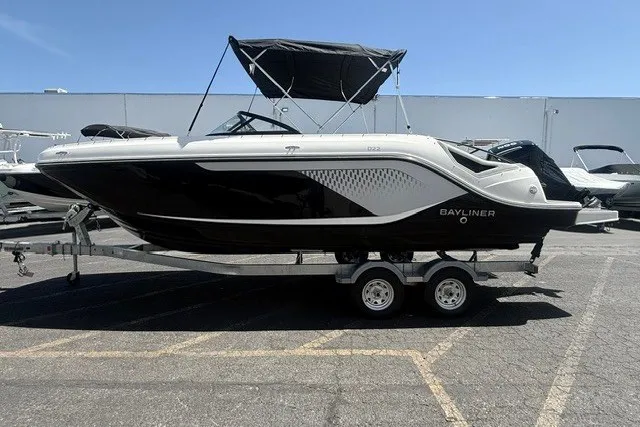 The Image of 2026 Bayliner D22 boat on trailer, black and white design, parked outdoors. - 1