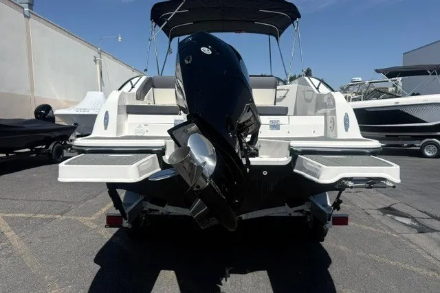 Slide: The Image of 2026 Bayliner D22 boat with outboard motor, parked in a marina under clear skies. - 22