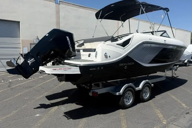 Slide: The Image of 2026 Bayliner D22 boat on trailer, parked outdoors, featuring a Mercury outboard motor. - 25