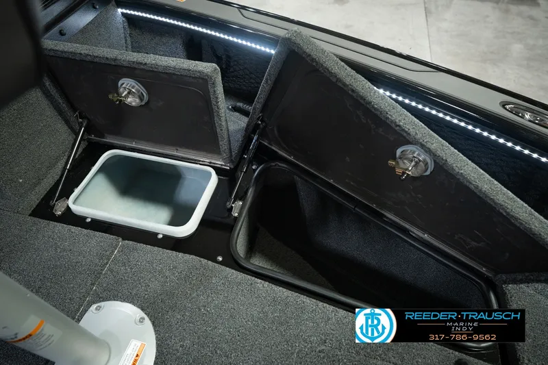 Slide: The Image of Interior storage compartments of 2026 Lund 1975 Pro-V Sport boat, featuring carpeted finish and LED lighting. - 35