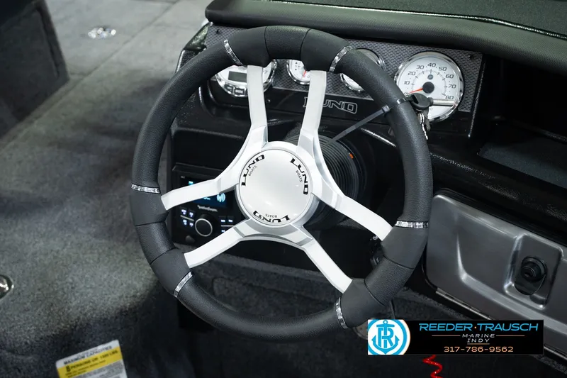Slide: The Image of Steering wheel of 2026 Lund 1975 Pro-V Sport boat with dashboard controls. - 36