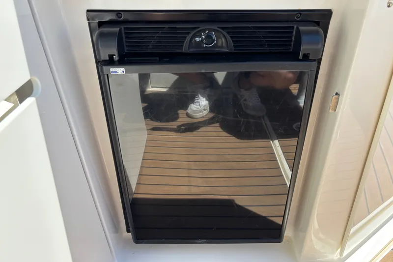 Slide: The Image of Built-in refrigerator on 2013 Sea Ray Sundancer 310 yacht, featuring sleek black design. - 9